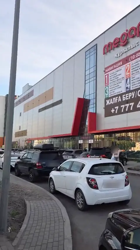 Въезд к ТРЦ Megapolis: поток машин вдоль фасада с LED-экраном